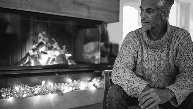 man sitting next to fireplace