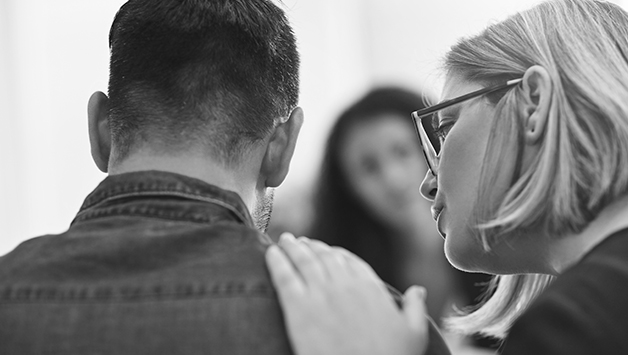 woman comforting man at funeral