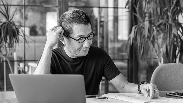 man puzzled while working at laptop