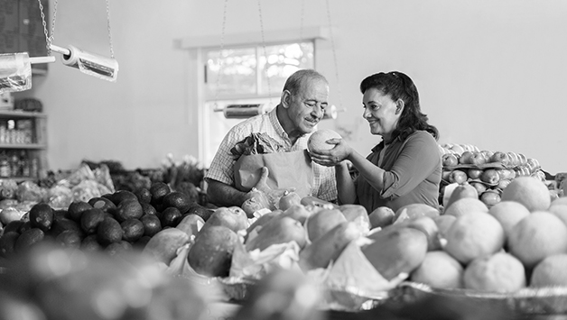 senior couple selecting fruit at store