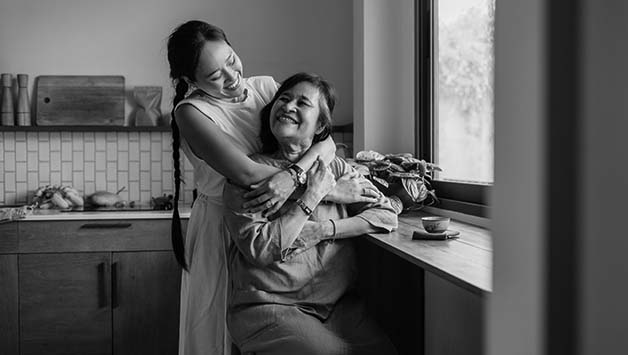 mother and daughter hugging in kitchen