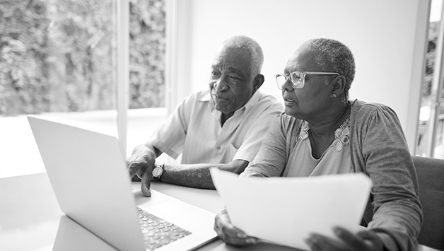 senior couple reading laptop together