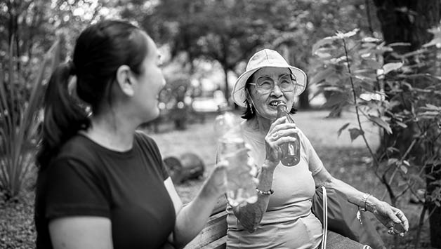 senior woman drinking water outside