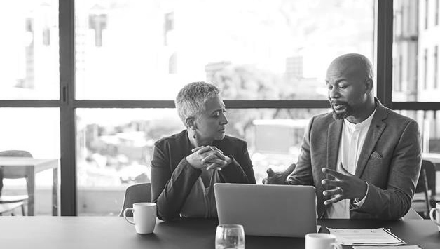 coworkers discussing work at laptop