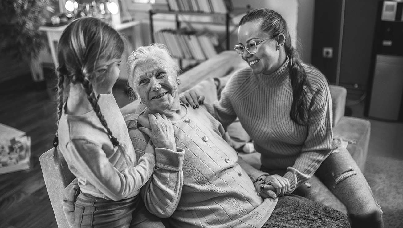 senior woman laughing with daughter and granddaughter