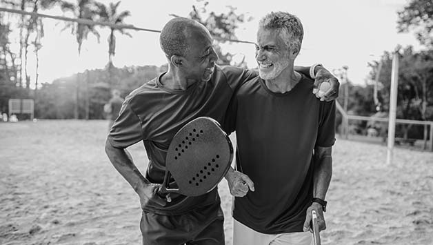 two senior men playing beach tennis